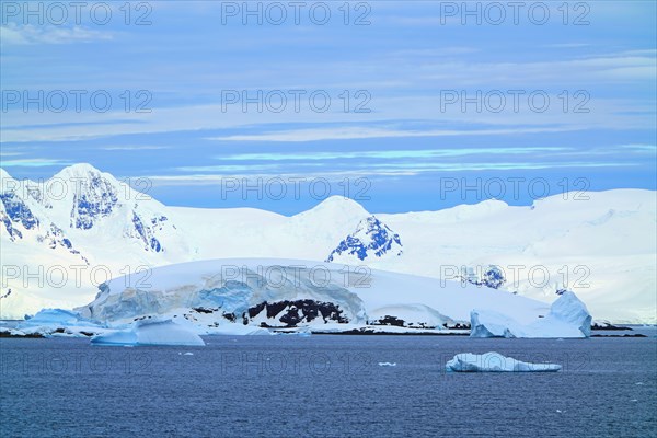 Various types of iceberg landscapes. There are ice floes, glaciers, oceans, radioactive clouds, sunshine, this is the Antarctic summer.