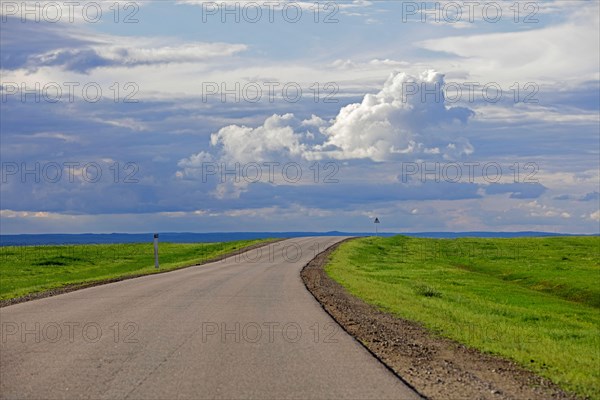 Empty road and rain clouds forming over the Gobi desert, rain shadow desert turning green in summer, Southern Mongolia