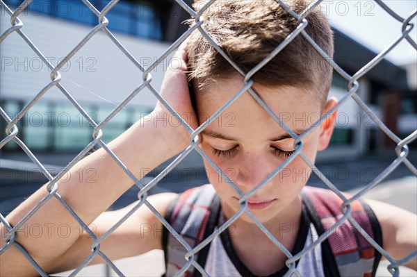 very sad boy bullying in school playground.