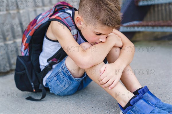 very sad boy bullying in school playground.