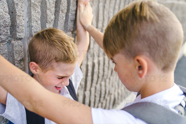 Cruel teenagers punching younger boy, physical intimidation, school bullying