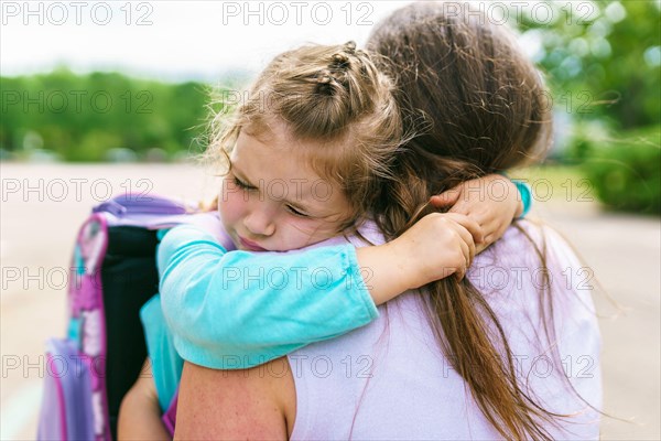 Mother and her daughter to school. Giving a big hug