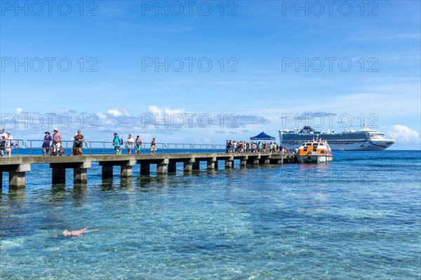Passengers being transferred to jetty by small tenders from cruise liner anchored off Kiriwina Island, Papua New Guinea