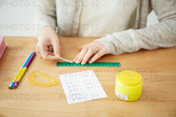 Woman attaching name stickers to school supplies