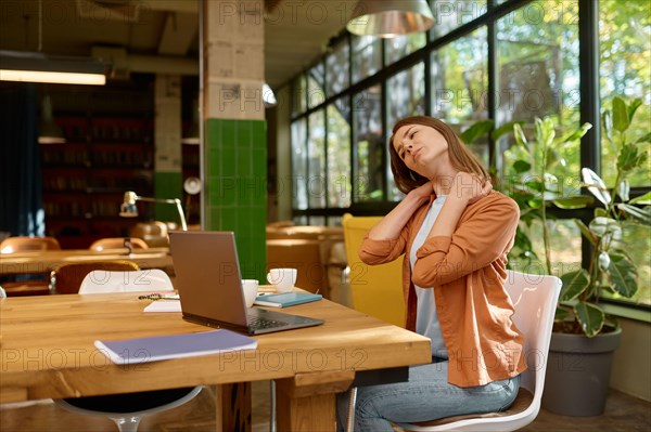 Tired young business woman working at coworking space