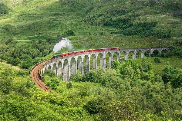 The Jacobite steam train on Glenfinnan viaduct in North West Highlands, Scotland, UK. The train and the bridge have been featured in the Harry Potter