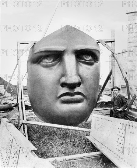 The bronze face of the Statue of Liberty uncrated awaiting installation in 1885 on Liberty Island, NY. The dark color is the result of oxidation of the copper material, which turned deeper brown, black, and eventually the light green color of fully oxidized copper.