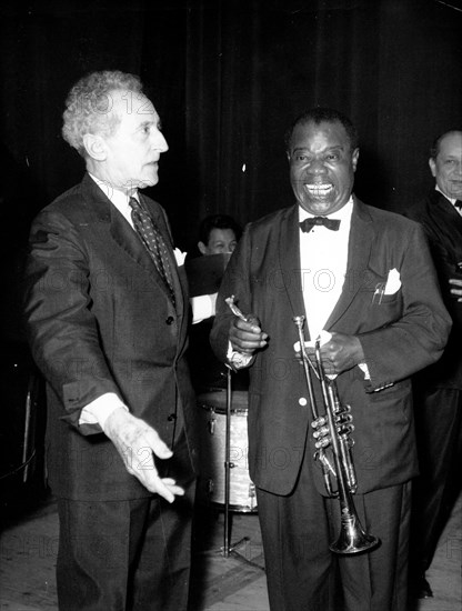 Jean Cocteau talking with a musician