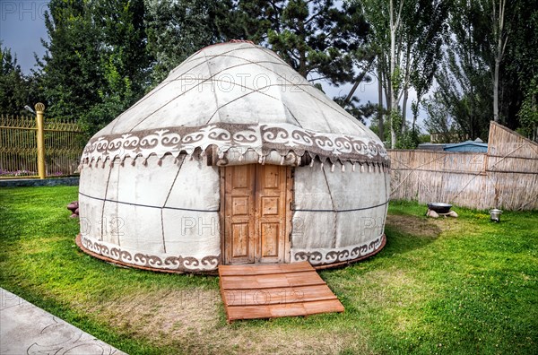 Urta nomadic house on the green grass in Ruh Ordo complex near Issyk Kul lake, Kyrgyzstan