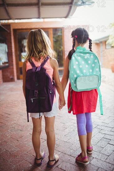 Rear view of two girls going to school