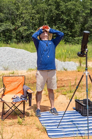 A photographer with solar binoculars observes the Great American Eclipse on August 21, 2017.