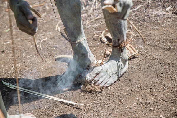 Asaro Mudmen performers making fire, Geremiaka village, Goroka area, Eastern Highlands Province, Papua New Guinea