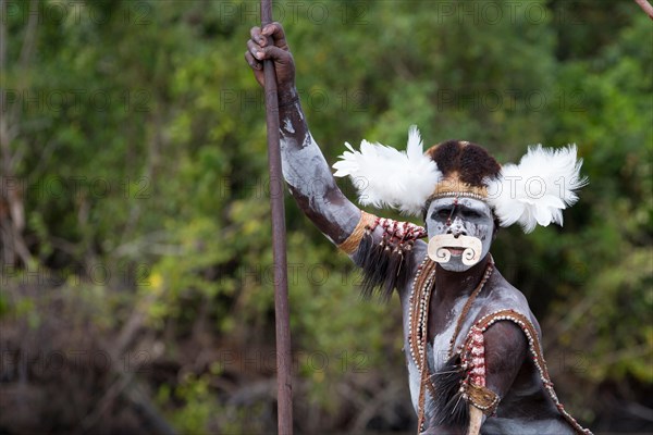 Local in traditional attire canoeing, Papua, Syuru village, Asmat region.