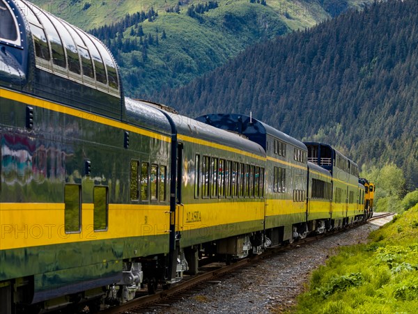 Snow capped mountains in background of Alaska Railroad’s Coastal Classic train from Anchorage to Seward Alaska