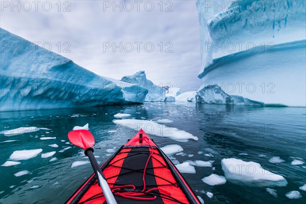 Kayaking in Antarctica between icebergs with inflatable kayak, extreme adventure in Antarctic Peninsula , beautiful pristine landscape, sea water padd