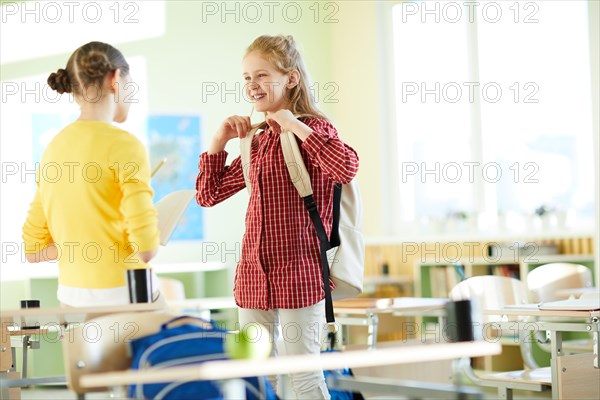 Excited girls discussing task in classroom