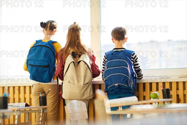 Dreamy school friends looking out window