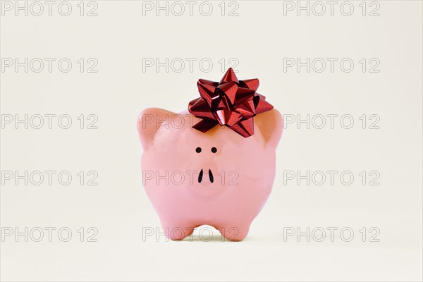 Piggy bank with red bow - Concept of giving away money bonus