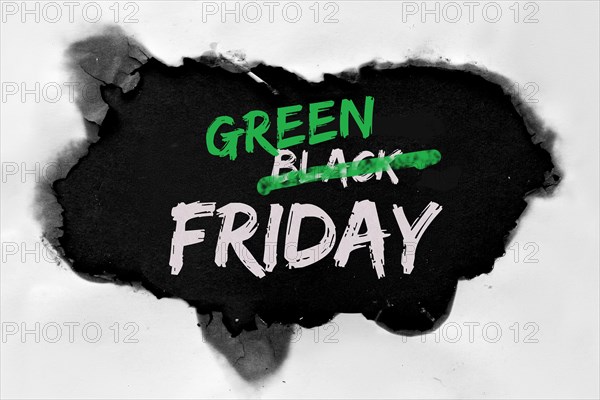 Green Friday concept with hole burned in white paper. Text "Black Friday Sale"  with word "Black" being crossed out. Strikethrough or strikeout effect