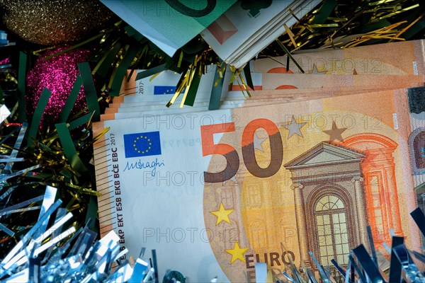 A lot of euro bills with colorful Christmas decorations.