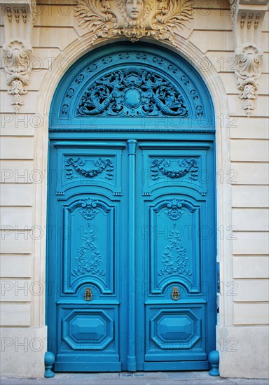 Old fashioned front door entrance, white facade and blue door, Paris, France