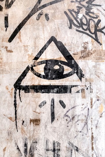 Illuminati logo painted on the wall. "All seeing eye" of God in sacred geometry triangle. Masonry and Illuminati symbol in triangle with light ray.