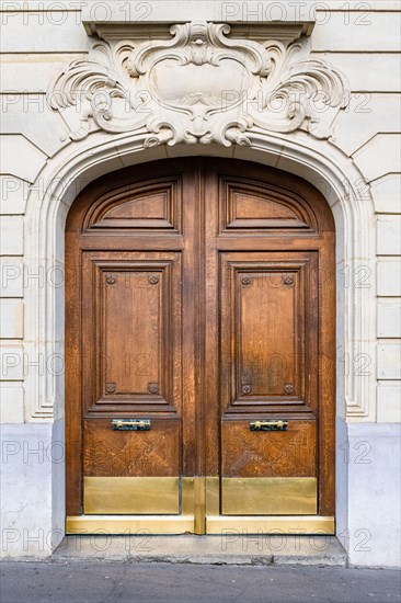 Paris, an ancient wooden door, beautiful facade in the 11e arrondissement