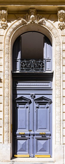 Paris, an ancient wooden door, typical building in the 11e arrondissement