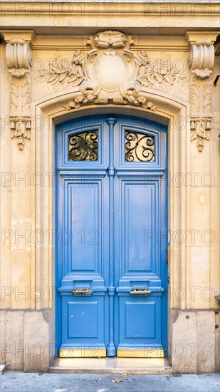 Paris, a blue wooden door, typical building in the center