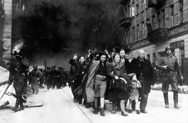 In January 1943 the nazis arrived to round up the Jews of the Warsaw Ghetto  The Jews, resolved to fight it out, took on the SS with homemade and primitive weapons. The defenders were executed or deported and the Ghetto area was systematically demolished. This event is known as The Ghetto Uprising. This image shows a column of captured women leaving the burning city.  This image is from the German photographic record of the event, known as the Stroop report.