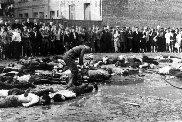 Lithuanian civilians and German soldiers watching the massacre of 68 Jews in the Lietukis garage of Kaunas, Lithuania on 25 or 27 June 1941.