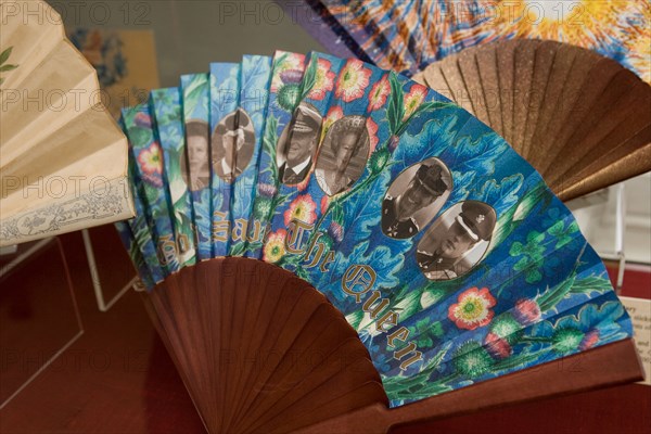 A fan depicting the British Royal Family with the slogan GOD SAVE THE QUEEN printed on it on display at the Fan Museum Greenwich