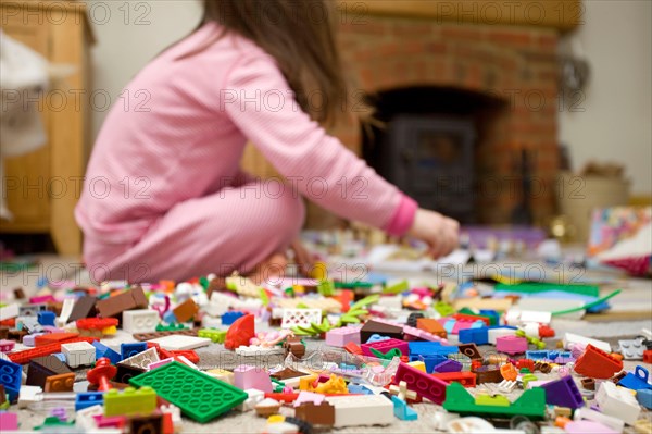 Child sat on floor playing with lego
