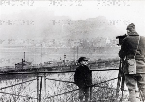 A movie man of the U.S. Sig. Corps, a member of the first American unit to enter the Coblenz with the 4th Div., filming panorama of the Rhine, with the fortress of Ehrenbreitstein in the background ca. 1918-1919