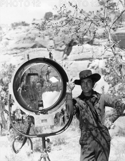 JOHNNY MACK BROWN publicity pose on set location candid next to Mole-Richardson movie light during location filming of  BILLY THE KID 1930 director KING VIDOR book Walter Noble Burns dialogue Laurence Stallings technical advisor William S. Hart Metro Goldwyn Mayer