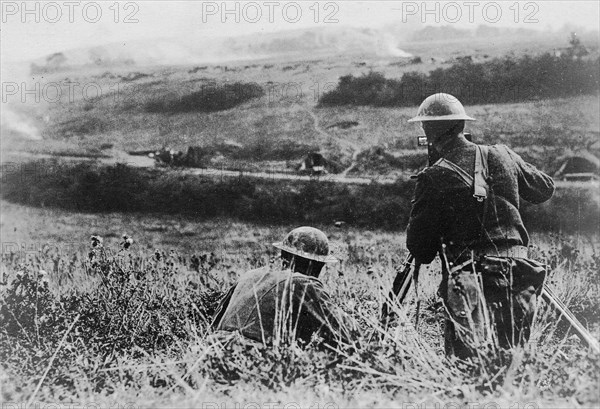 A cameraman filming an American artillery battery being shelled out of its position. France, 1918.