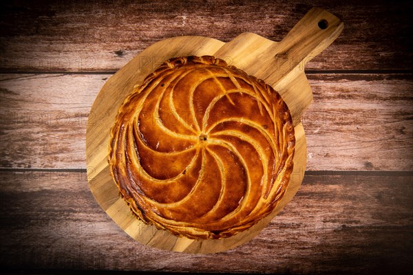 Galette des rois on wooden table, Traditional Epiphany cake in France