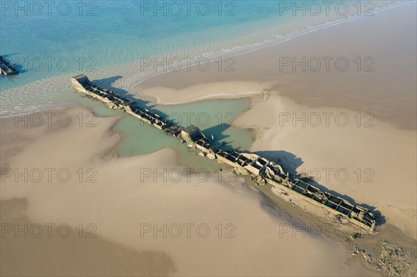 This landscape photo was taken in Europe, France, Normandy, Arromanches les Bains, in summer. We see the remains of the artificial port of Gold beach