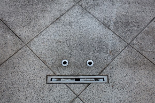 Details in a floor resemble a face in an example of pareidolia. Tokyo, Japan.