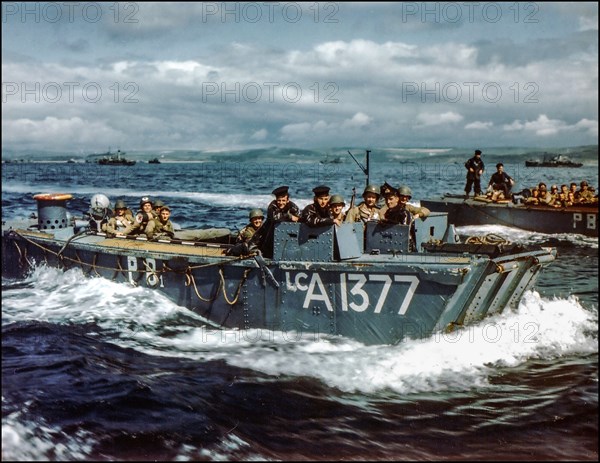 D-Day rehearsals WW2 1944  British Navy Landing Craft LCA-1377 in preparations for D-Day, carries American troops to a ship, in a British port during preparations for the Normandy invasion, circa May-June 1944. British Sailors in the boat's conning station.
Letters "PB" on the boat's side indicate that it is assigned to HMS Prince Baudouin. 1 May 1944 
Operation Overlord World War II Second World War