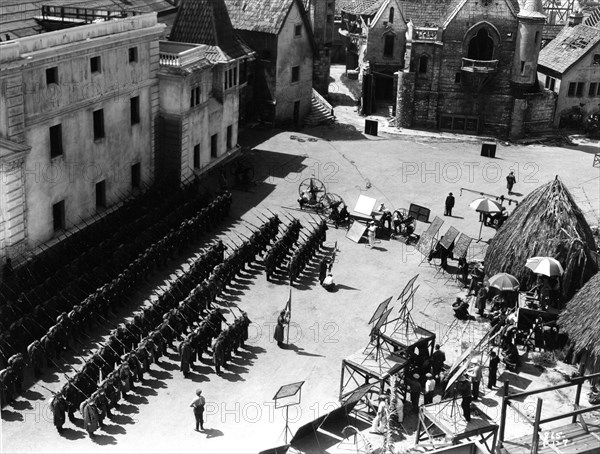 On Set candid filming Parade of German Soldiers on Universal Studios Lot with part of Paris set from Lon Chaney's Hunchback of Notre Dame (1923) at top right and Native Huts from The Invisible Ray (1936) (with Boris Karloff and Bela Lugosi) behind the Movie / Camera Crew during filming of THE ROAD BACK 1937 director JAMES WHALE novel Erich Maria Remarque music Dimitri Tiomkin art direction Charles D. Hall Universal pictures