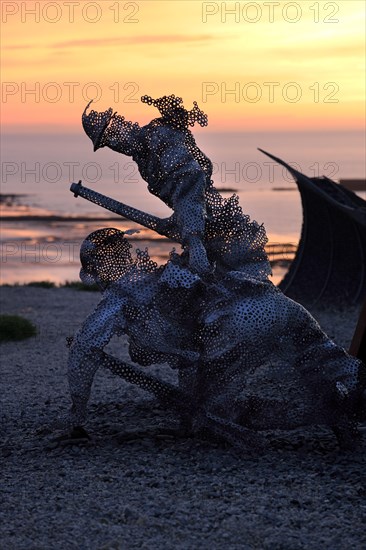 Life size sculptural figure in the D-Day 75 Garden in Arromanches-les-Bains, France at Sunset. The installation was first created by John Everiss for