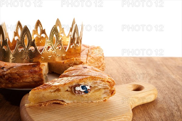 King cake or galette des rois in French. Epiphany pie with golden paper crown and little ceramic figurine