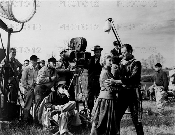 1959 : The  celebrated movie actors  JOHN WAYNE  in a pubblicitary shot for the movie  THE HORSE SOLDIERS ( Soldati a cavallo ) by John Ford . In this photo with the director JOHN FORD and the actress CONSTANCE TOWERS  - CINEMA - ATTORE CINEMATOGRAFICO - sex symbol  -  FILM -  embrace - abbraccio - sul SET - STAGE --- NOT FOR ADVERTISING USE -- NON PER USO PUBBLICITARIO ----NOT FOR GADGET USE --- ----  Archivio GBB