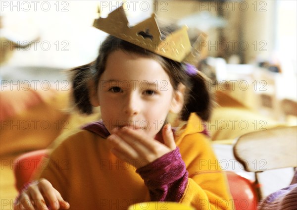 Child with paper crown on head, portrait.