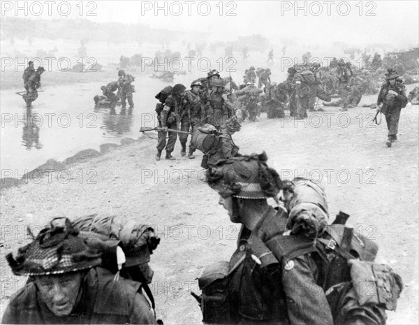 D-DAY 6 June 1944. British soldiers  struggle ashore on SWORD  beach in Normandy- see Description below for details