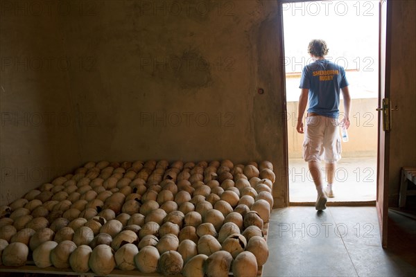 An English public schoolboy leaves a room full of skulls of victims from the 1994 Rwandan genocide .