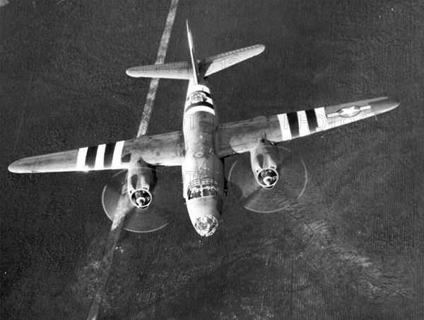 A B-26 Marauder flies with invasion stripes for D-Day.