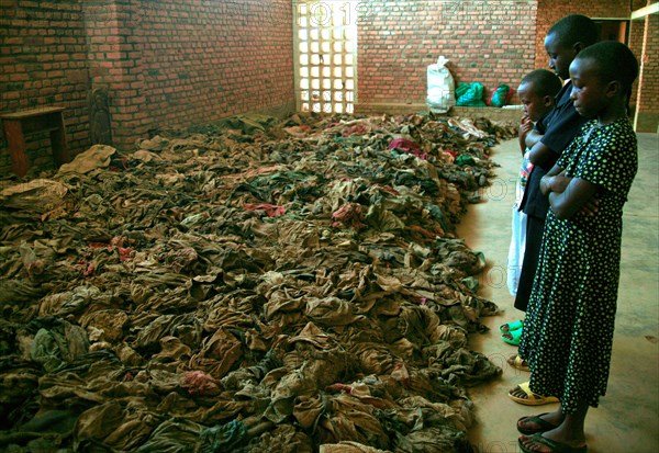 Children standing in a church in rural Rwanda and looking at remains opeople killed during the 1994 genocide