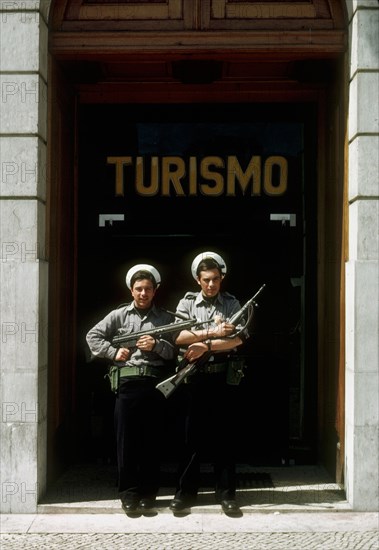 Portuguese marines stand guard outside the tourism office in Lisbon, with flowers in their guns, following the 'Carnation Revolution, the bloodless military coup of 25 April 1974 which deposed the authoritarian Salazar regime and began Portugal's transition to democracy